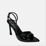 Black high-heeled shoe on a white surface with a neutral background